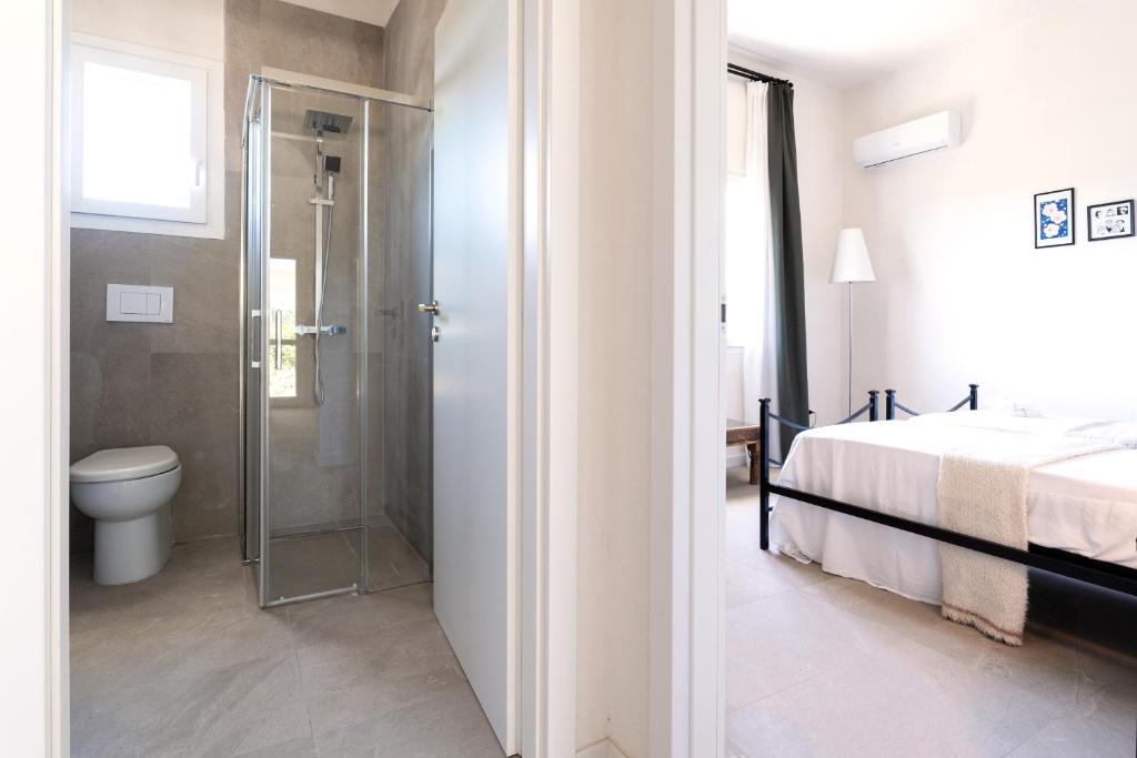 La salle de bains est pourvue d'une douche, d'un lit et de toilettes. dans l'établissement Meraki house con piscina privata, à San Michele Salentino