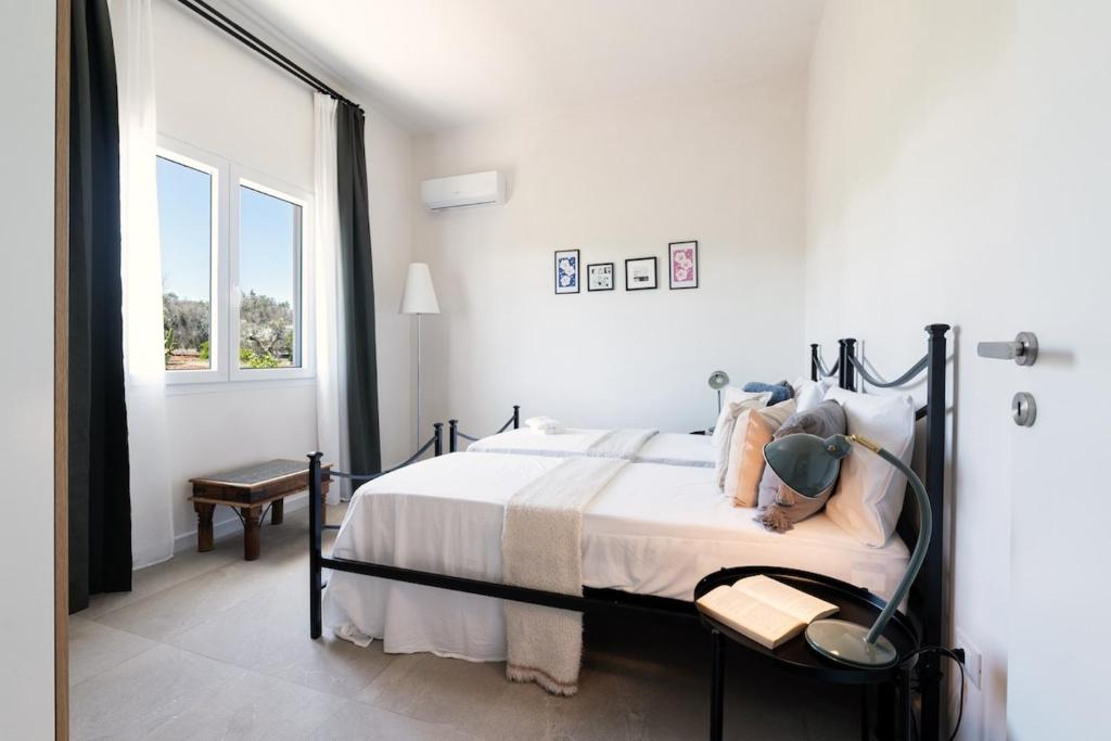 - une chambre avec un lit aux murs blancs et une fenêtre dans l'établissement Meraki house con piscina privata, à San Michele Salentino