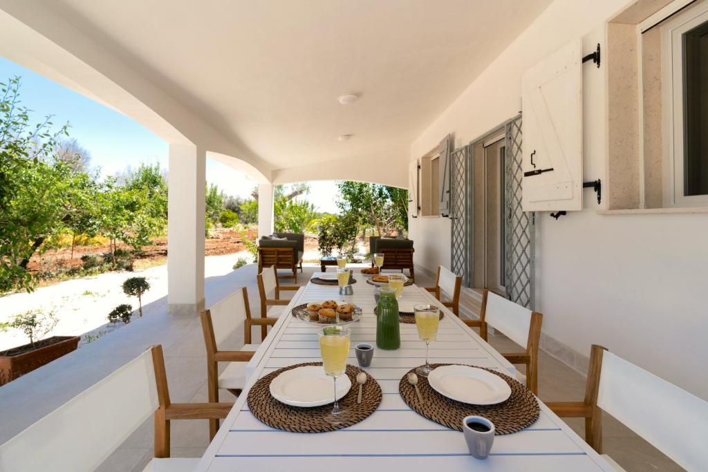 une salle à manger extérieure avec une table et des chaises dans l'établissement Meraki house con piscina privata, à San Michele Salentino