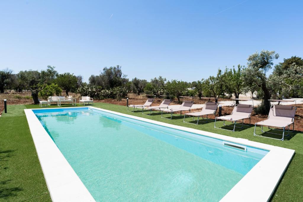- une piscine avec des chaises longues dans la cour dans l'établissement Meraki house con piscina privata, à San Michele Salentino