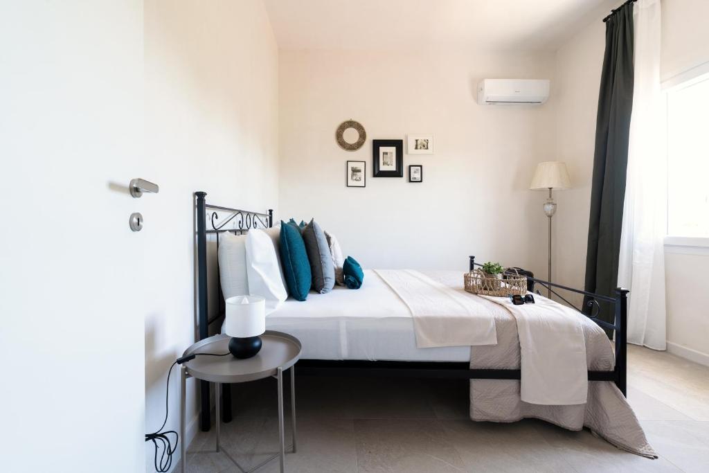 une chambre blanche avec un lit et une table dans l'établissement Meraki house con piscina privata, à San Michele Salentino