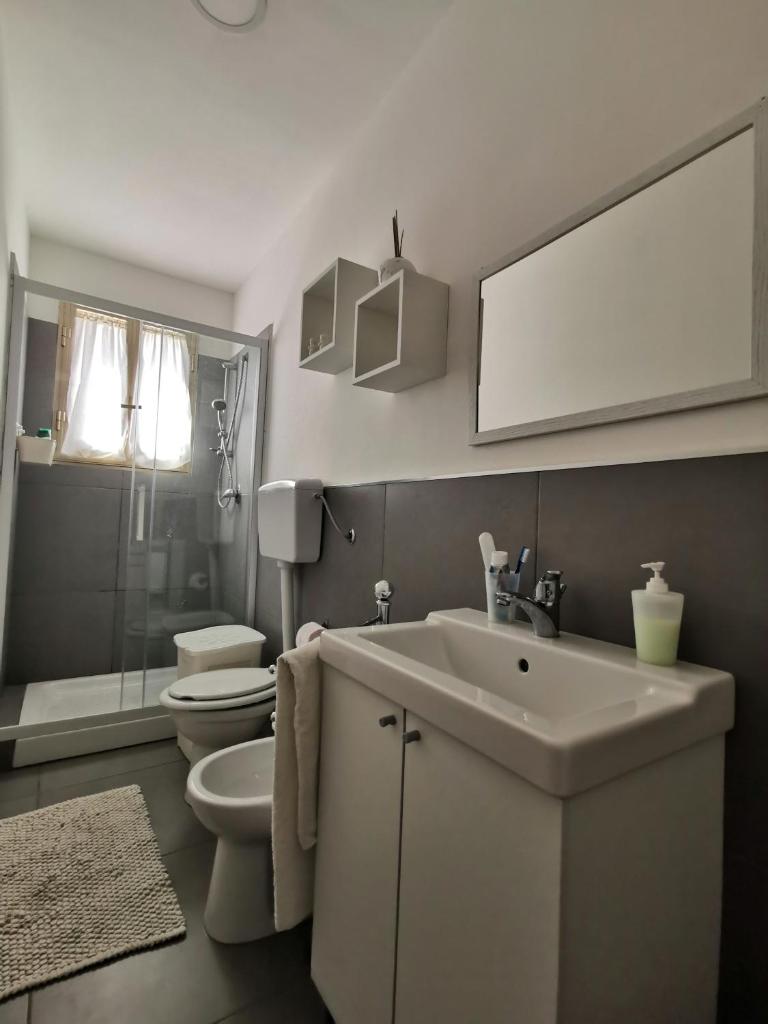 une salle de bain avec un lavabo, des toilettes et un miroir dans l'établissement Villa Matilde, à Marina di Ragusa 15 autres photos