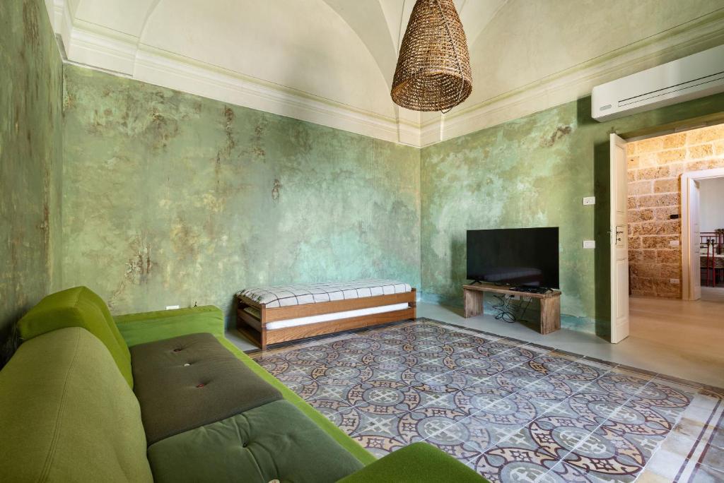 un salon avec un canapé et une télévision dans l'établissement La Casa Della Maestra by Perle di Puglia, à Presicce