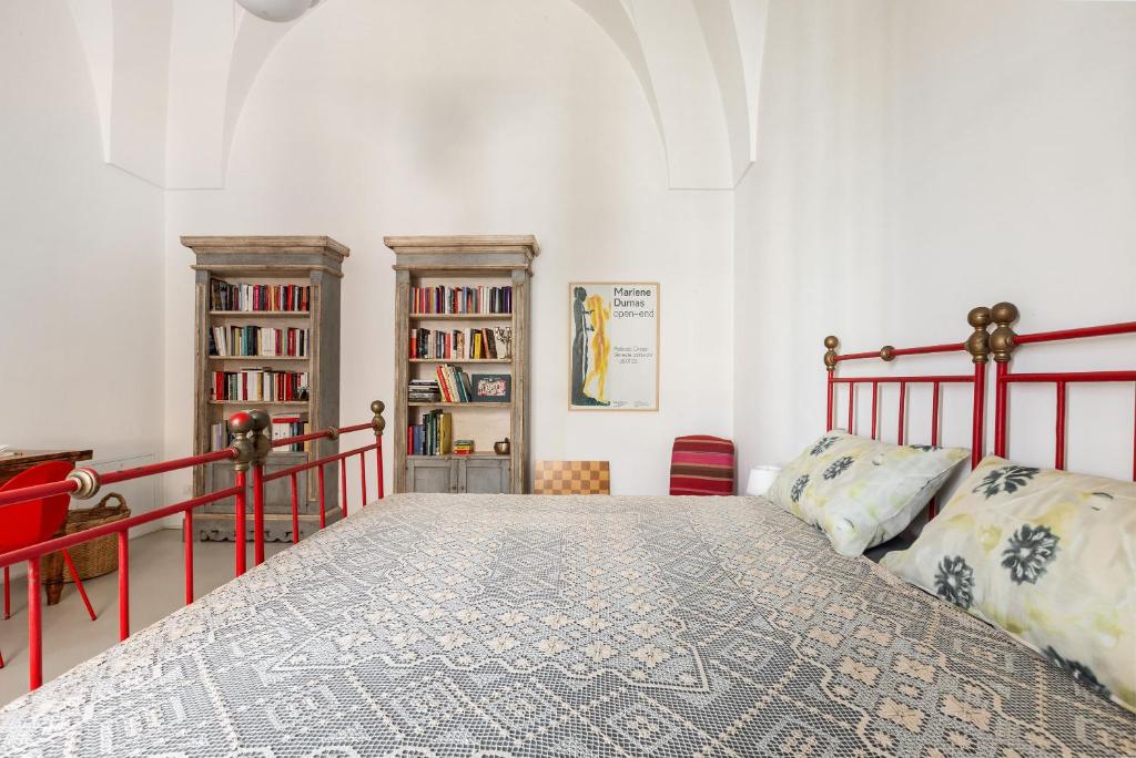 une chambre avec un lit et une étagère dans l'établissement La Casa Della Maestra by Perle di Puglia, à Presicce