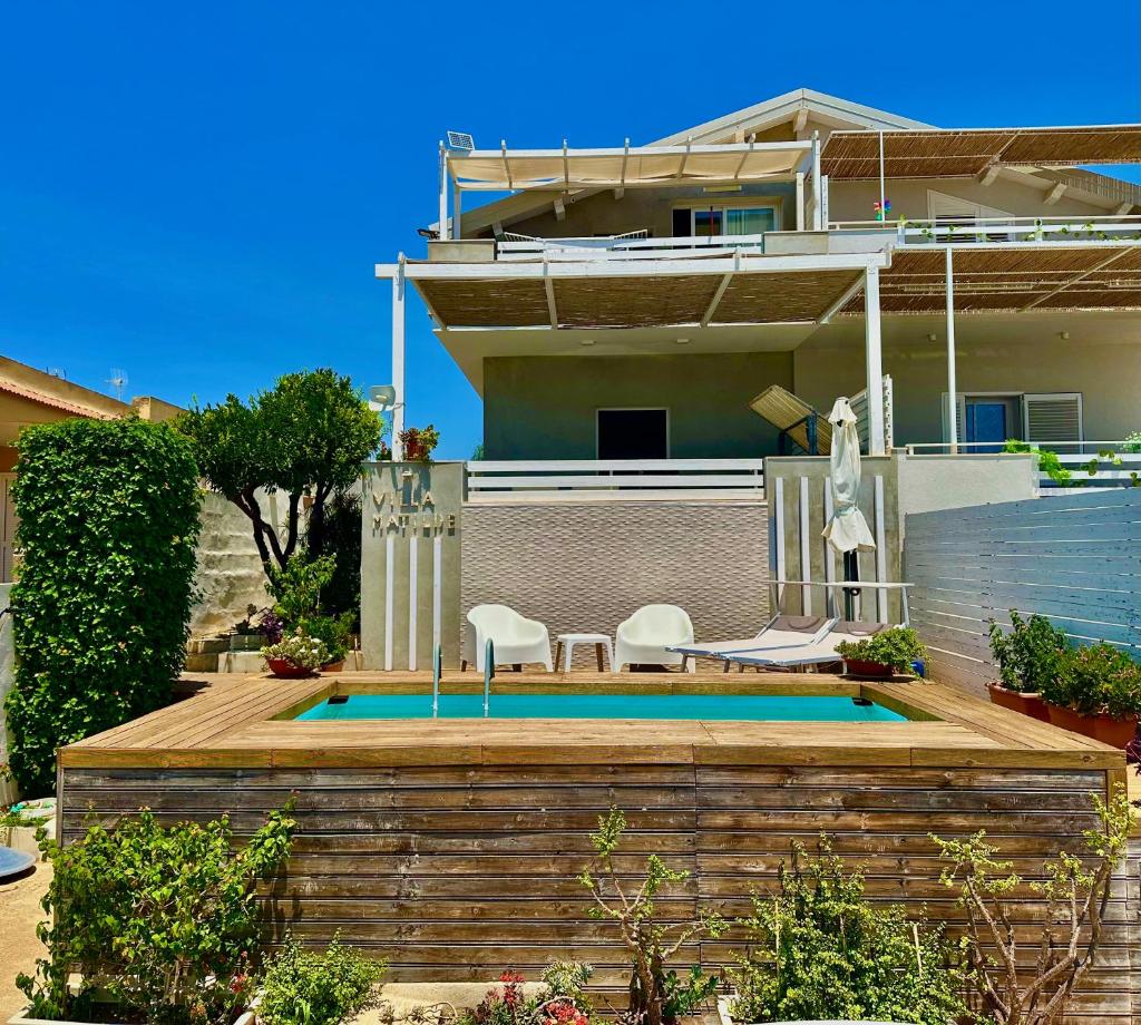 une maison avec une piscine devant une maison dans l'établissement Villa Matilde, à Marina di Ragusa