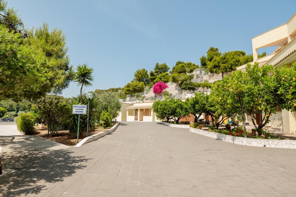 une rue avec un bâtiment et des arbres et un bâtiment dans l'établissement Hotel Sfinalicchio, à Vieste
