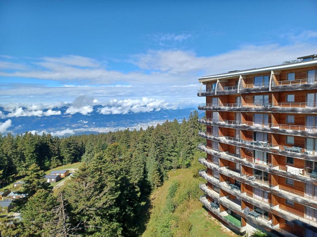 - un bâtiment avec vue sur les montagnes dans l'établissement Résidence l'Ecrin des Neiges, à Chamrousse