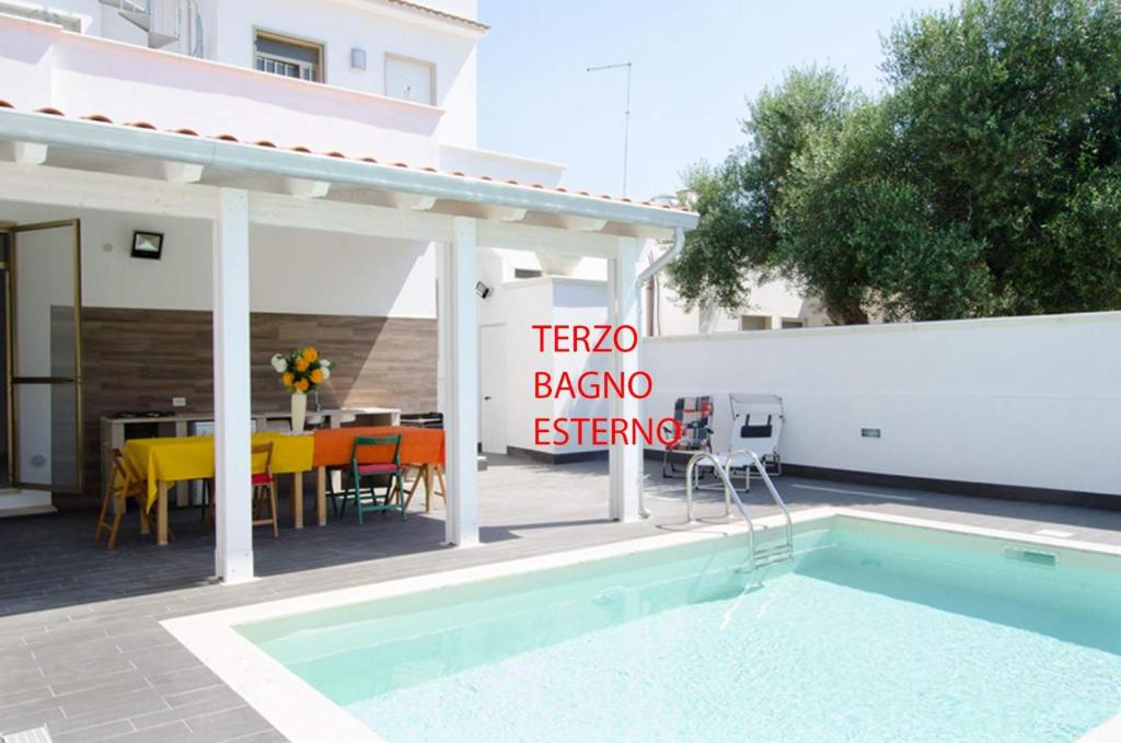 un panneau à côté d'une piscine à côté d'un restaurant dans l'établissement Villa Maria con Piscina nel Boomerang Village a Torre Colimena, à Torre Colimena