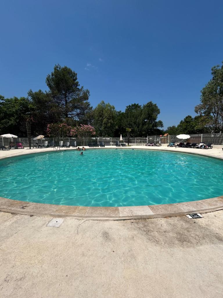 une grande piscine avec de l'eau bleue dans l'établissement Mobil-Home au pied du Luberon, à La Roque-dʼAnthéron