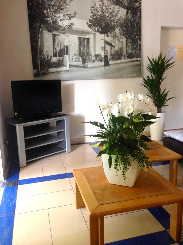 un salon avec un vase de fleurs sur une table dans l'établissement Hotel Jole, à San Mauro a Mare