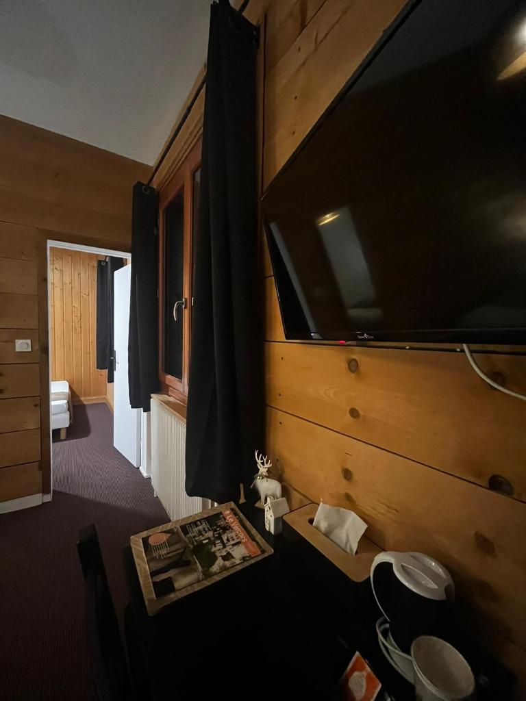 Cette chambre dispose d'une grande télévision murale. dans l'établissement Hôtel Au Feu De Bois bar à vin le 1605, à Autrans