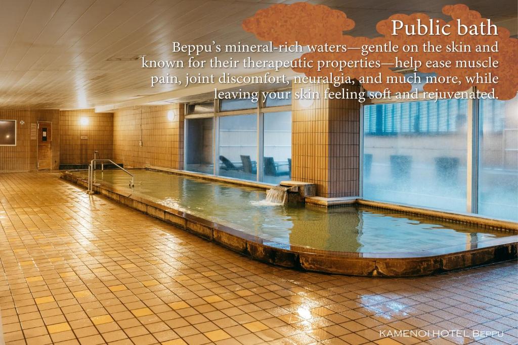 une grande piscine d'eau dans un bâtiment dans l'établissement KAMENOI HOTEL Beppu, à Beppu