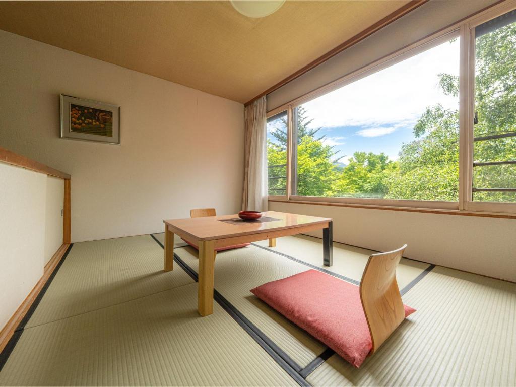 une pièce avec une table et une grande fenêtre dans l'établissement Okunikko Konishi Hotel, à Nikkō