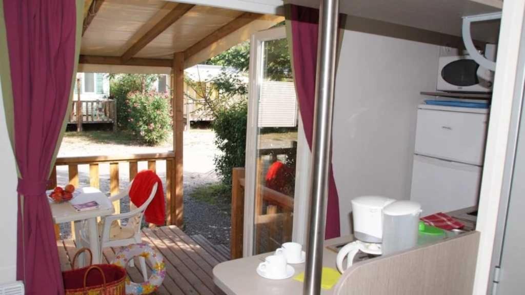 une vue d'un porche avec une terrasse avec une table dans l'établissement Camping 5 étoiles - Parc aquatique - eebafe, au Muy