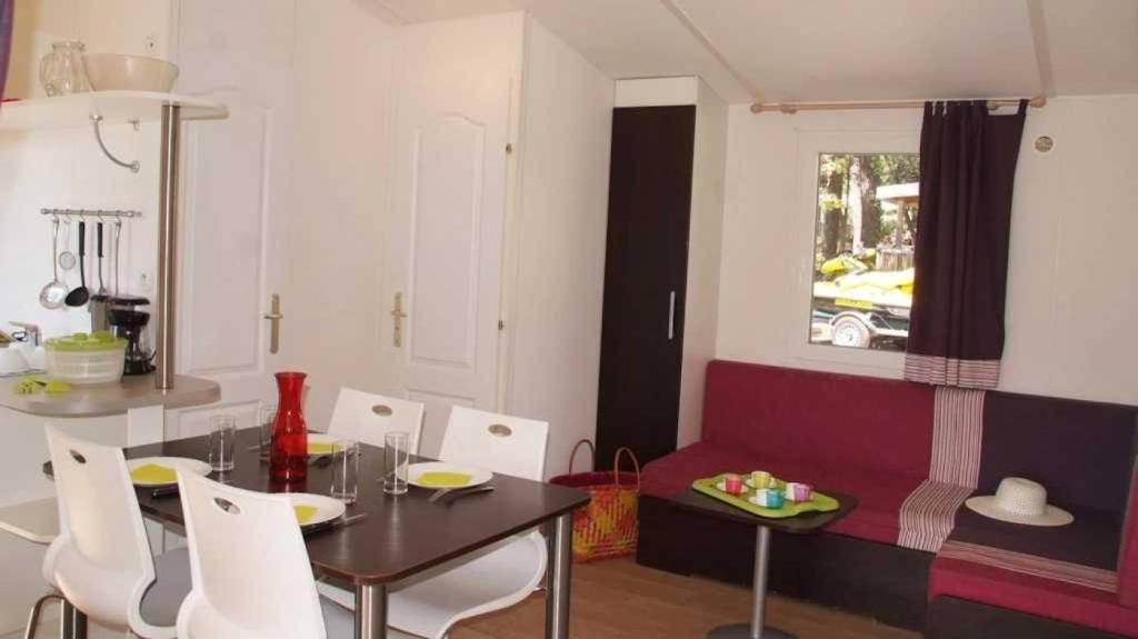 un salon avec une table et un canapé rouge dans l'établissement Camping 5 étoiles - Parc aquatique - eebafe, au Muy
