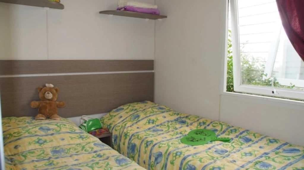 - une petite chambre avec 2 lits et un ours en peluche dans l'établissement Camping 5 étoiles - Parc aquatique - eebafe, au Muy