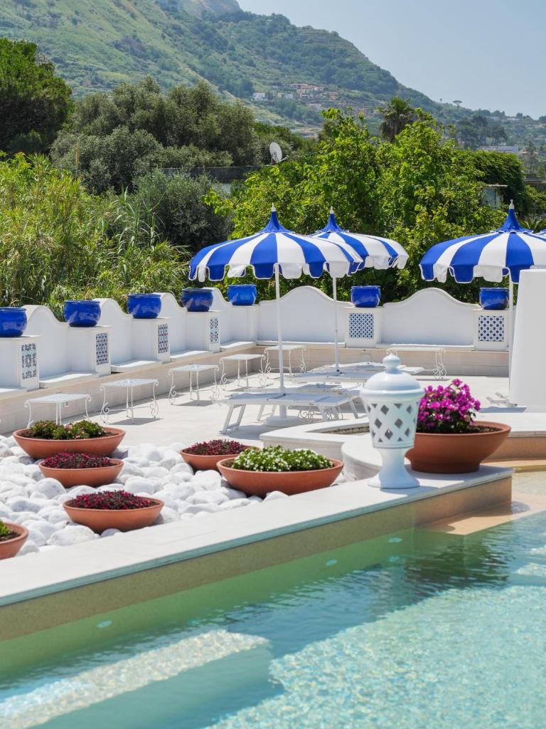 une rangée de plantes parsemées sur une table à côté d'une piscine dans l'établissement Corallo Blu Hotel De Charme - Sea & Spa access, à Ischia