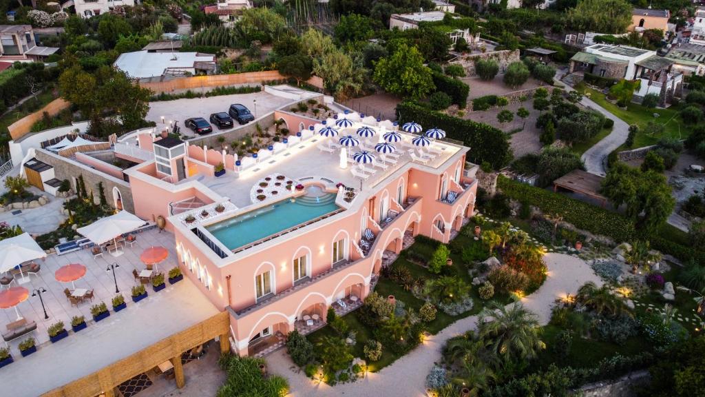 une vue aérienne d'un manoir rose avec une piscine dans l'établissement Corallo Blu Hotel De Charme - Sea & Spa access, à Ischia