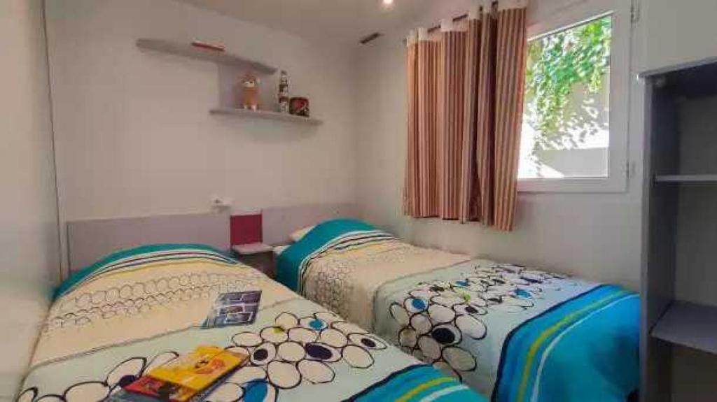 deux lits jumeaux dans une chambre avec fenêtre dans l'établissement Appartement 4 étoiles - Parc aquatique - ccaa0ai, à Bormes-les-Mimosas 37 autres photos