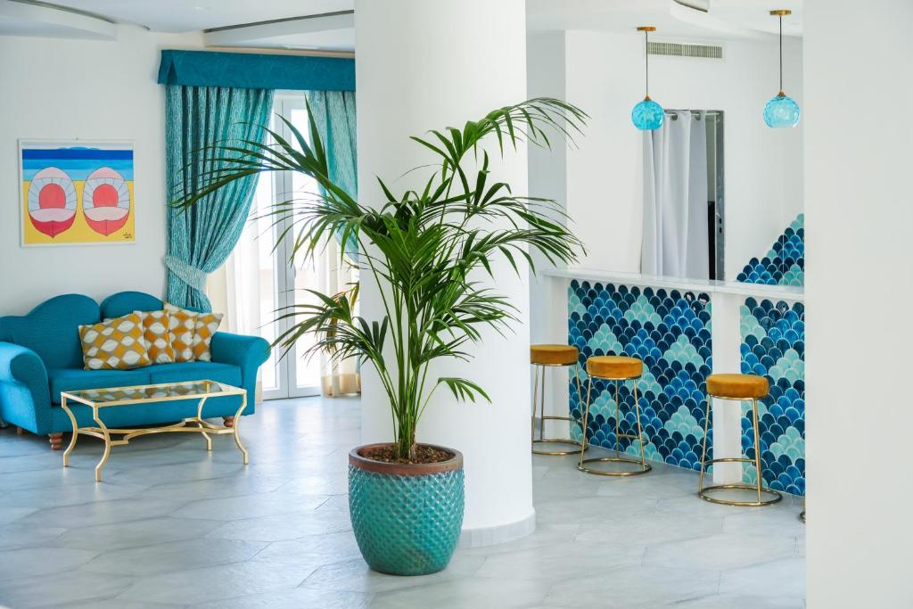 - un salon avec un canapé bleu et un palmier dans l'établissement Corallo Blu Hotel De Charme - Sea & Spa access, à Ischia 49 autres photos