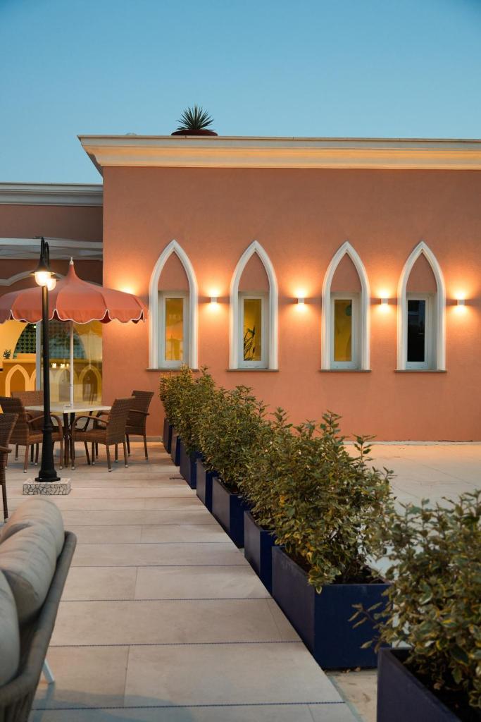 - un bâtiment avec une terrasse dotée de tables et de chaises dans l'établissement Corallo Blu Hotel De Charme - Sea & Spa access, à Ischia