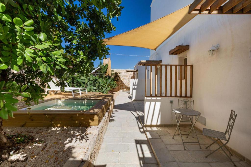 un patio avec une table et des chaises à côté d'un bâtiment dans l'établissement Villa Elena Nina by BarbarHouse, à Torre Lapillo