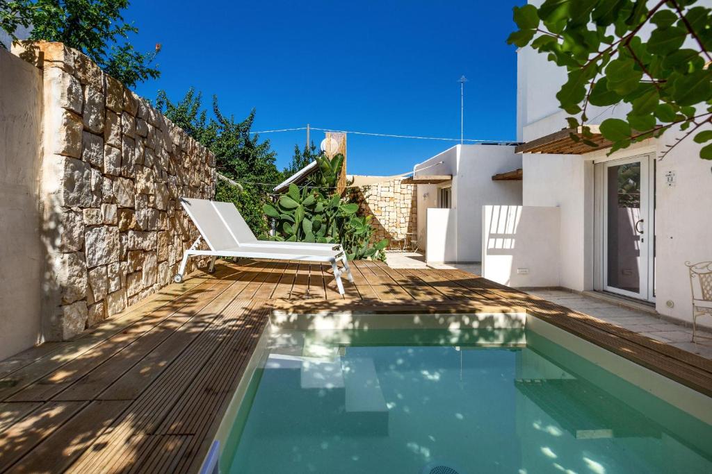 une villa avec une piscine et une chaise dans l'établissement Villa Elena Nina by BarbarHouse, à Torre Lapillo