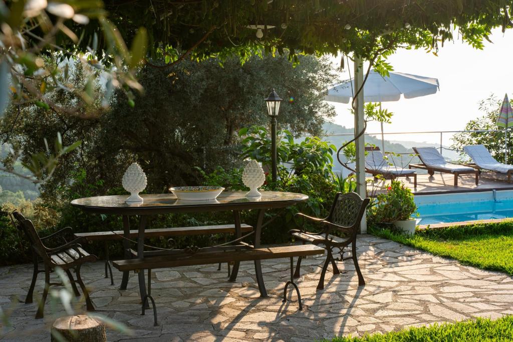 - une table et des chaises à côté de la piscine dans l'établissement Villa in campagna con piscina, à San Fratello 50 autres photos