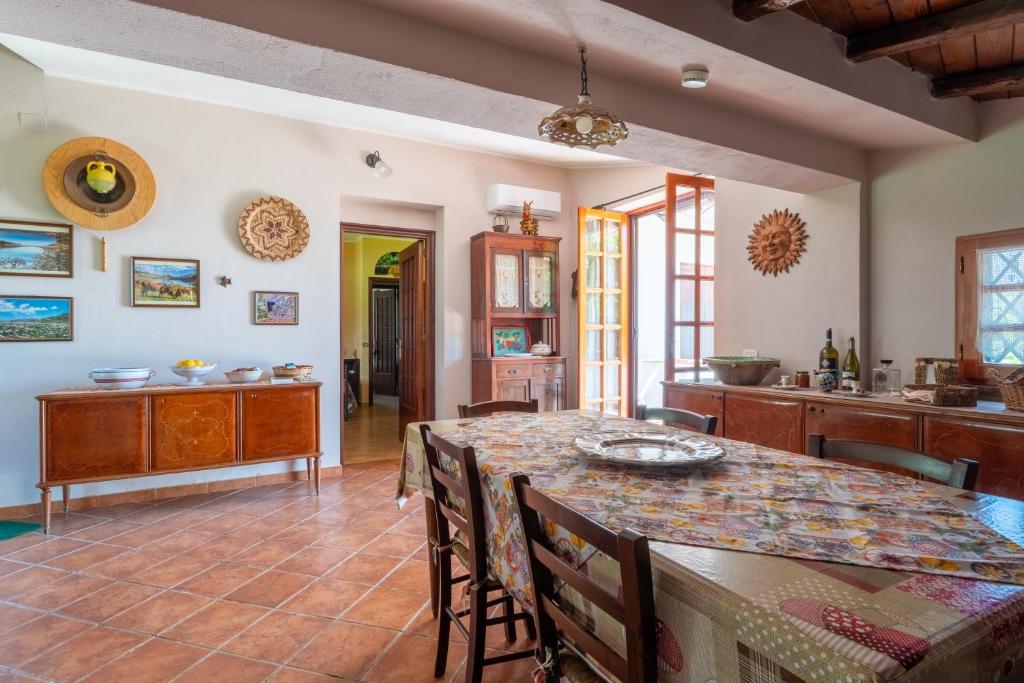 une cuisine et une salle à manger avec une table et des chaises dans l'établissement Villa in campagna con piscina, à San Fratello