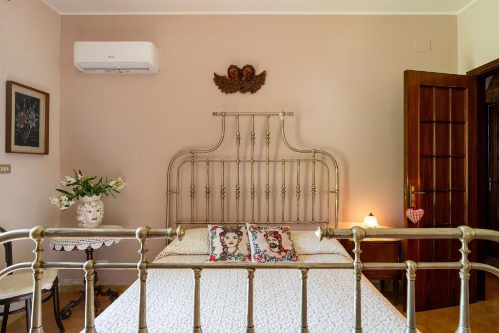 une chambre avec un lit en métal avec deux oreillers dans l'établissement Villa in campagna con piscina, à San Fratello