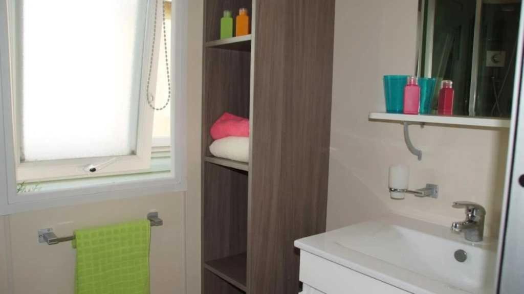 une salle de bain avec un lavabo et des toilettes et une fenêtre dans l'établissement Camping 4 étoiles - Parc aquatique - eec0ef, à Agay