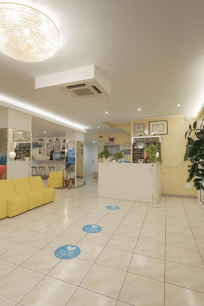 un salon avec un canapé jaune et une table dans l'établissement Hotel Imperiale, à Cesenatico