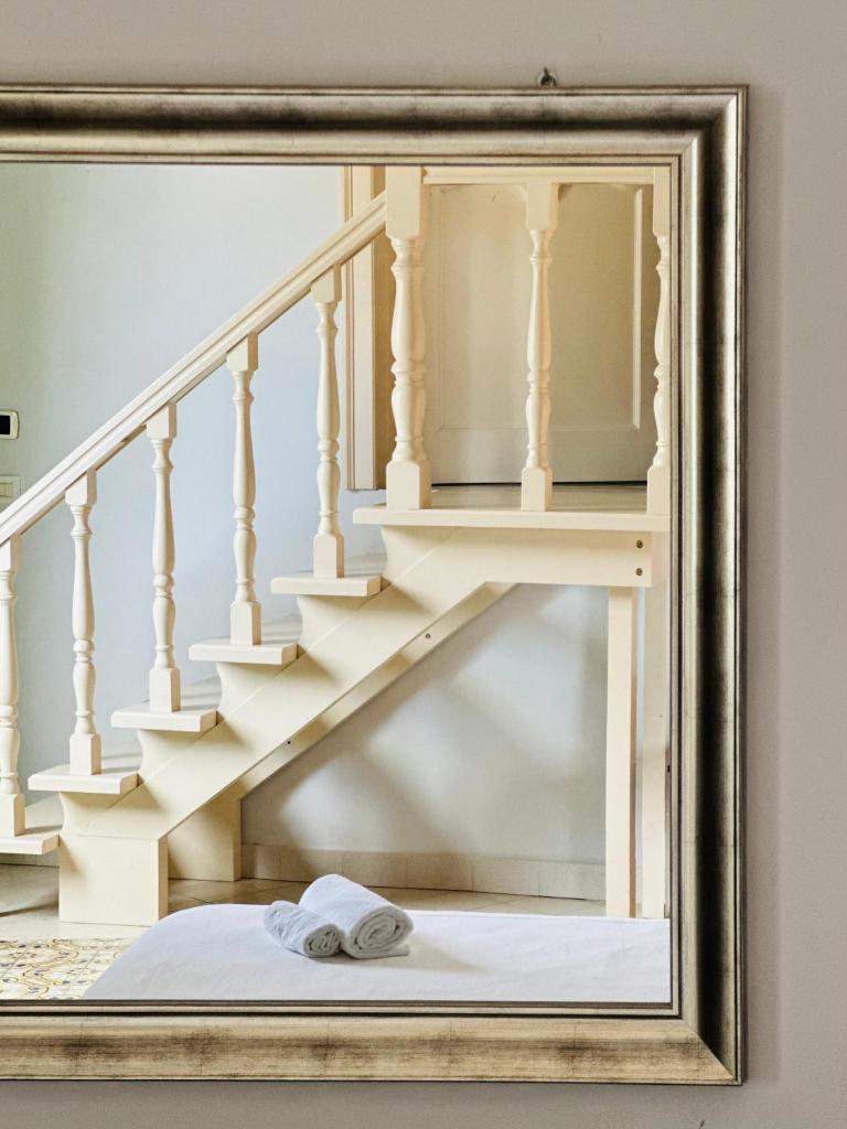 un miroir avec une serviette sur le sol à côté d'un escalier dans l'établissement Hotel Borgo di Ciàula, à Santa Flavia