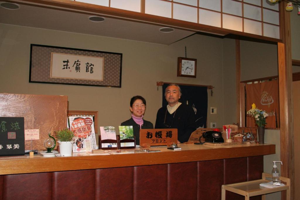 un homme et une femme debout à un comptoir dans l'établissement Suehirokan, à Tagami 34 autres photos