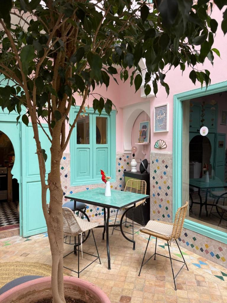 d'une terrasse avec une table, des chaises et un arbre. dans l'établissement Riad Lauriers Blancs, à Marrakech