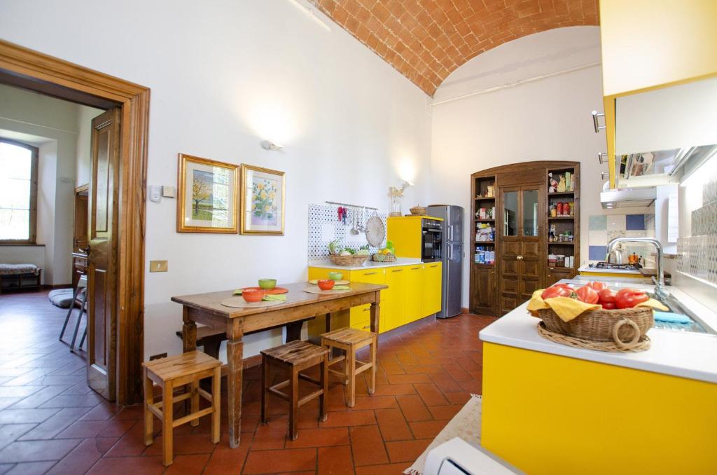 une cuisine avec une table en bois et des appareils jaunes dans l'établissement Villa Piandisette, à Cetona