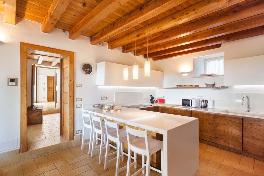 Il comprend une cuisine dotée d'un comptoir blanc et de plafonds en bois. dans l'établissement Villa Tenuta Campetti, à Caprino Veronese