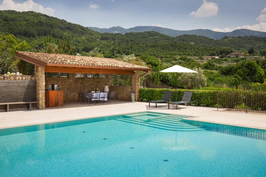 - une piscine avec une terrasse et une maison dans l'établissement Villa Tenuta Campetti, à Caprino Veronese