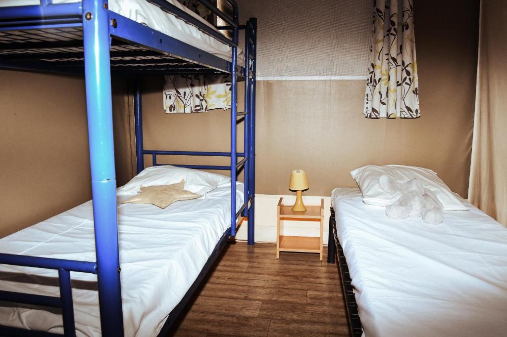 - une chambre avec 2 lits superposés et une table avec une lampe dans l'établissement Camping Les Amandiers, à Collioure