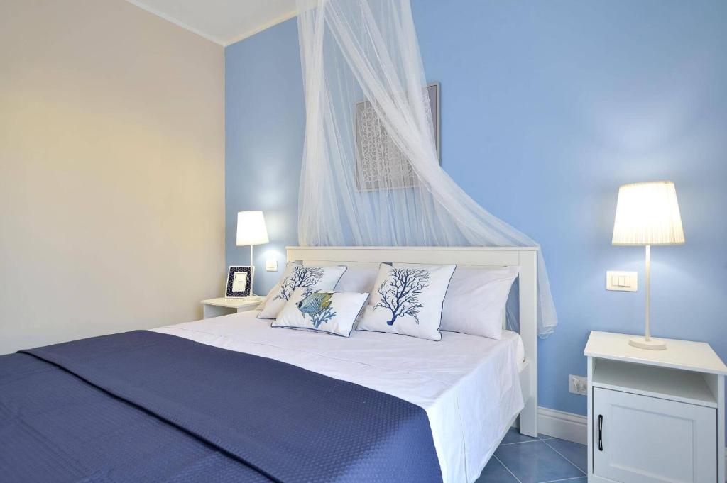 une chambre avec un lit blanc avec deux oreillers dans l'établissement Villa Rosso Blu by Villa Plus, à Santa Maria Del Focallo