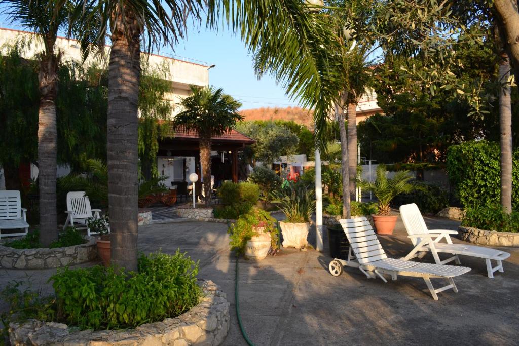 - deux chaises et des palmiers dans une cour dans l'établissement Villa Virginia, à Pellaro