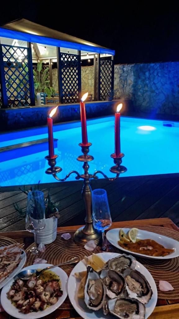 - une table avec des assiettes de nourriture à côté de la piscine dans l'établissement VIlla Sunlight Sardegna, à Santa Luria