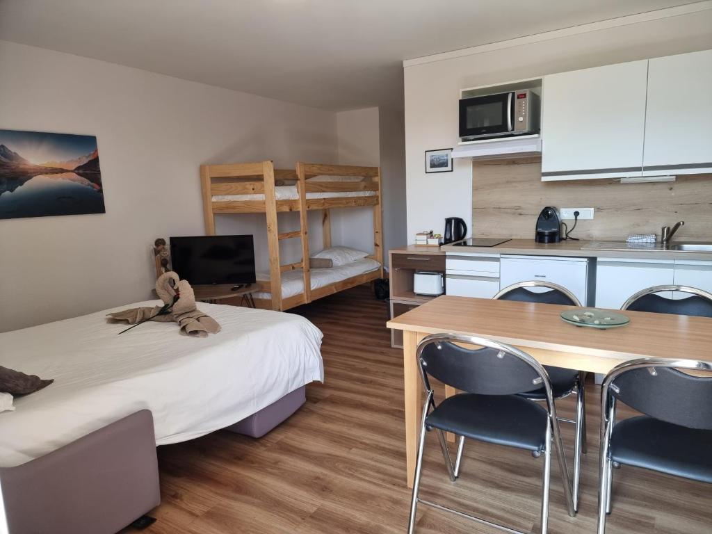 une petite pièce avec un lit, une table et des chaises dans l'établissement Studio Le Panoramic les Balcons d'Aix, à La Féclaz