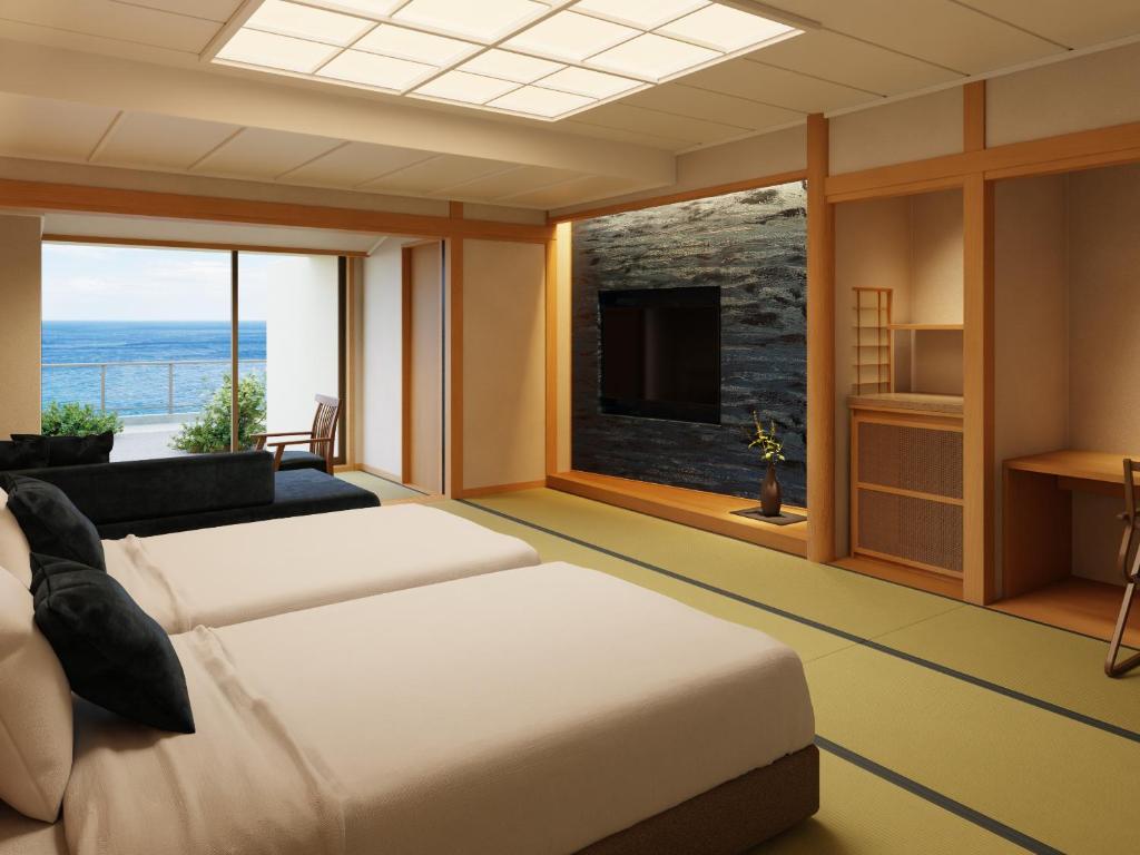 une chambre avec deux lits et une vue sur l'océan dans l'établissement IZU RETREAT by Onko Chishin, à Higashiizu