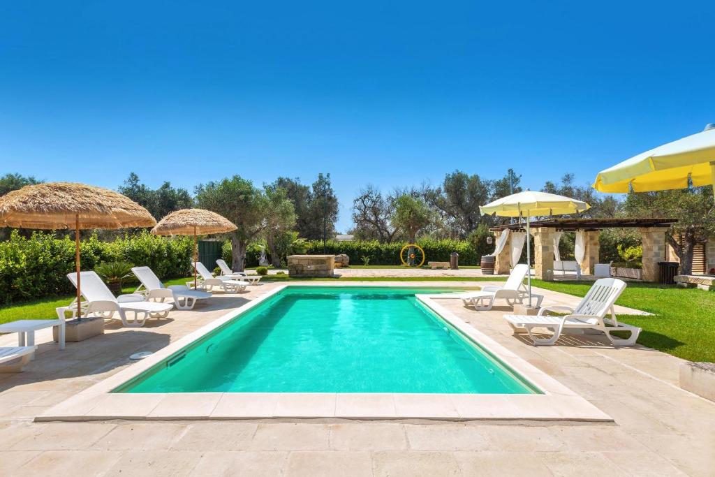 une piscine avec chaises et parasols dans l'établissement Villa Saracino by Perle di Puglia, à Supersano