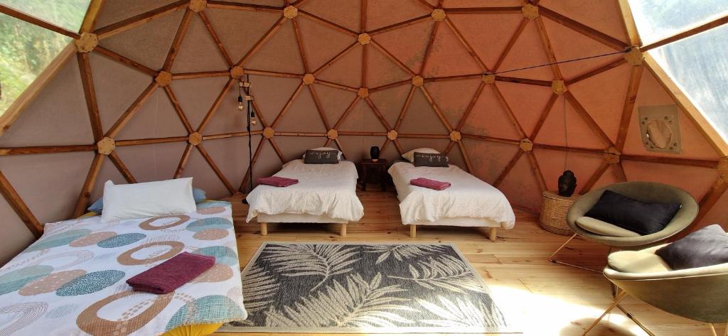 - une chambre avec 2 lits et 2 chaises dans une yourte dans l'établissement Sottu E Stelle, à Albitreccia