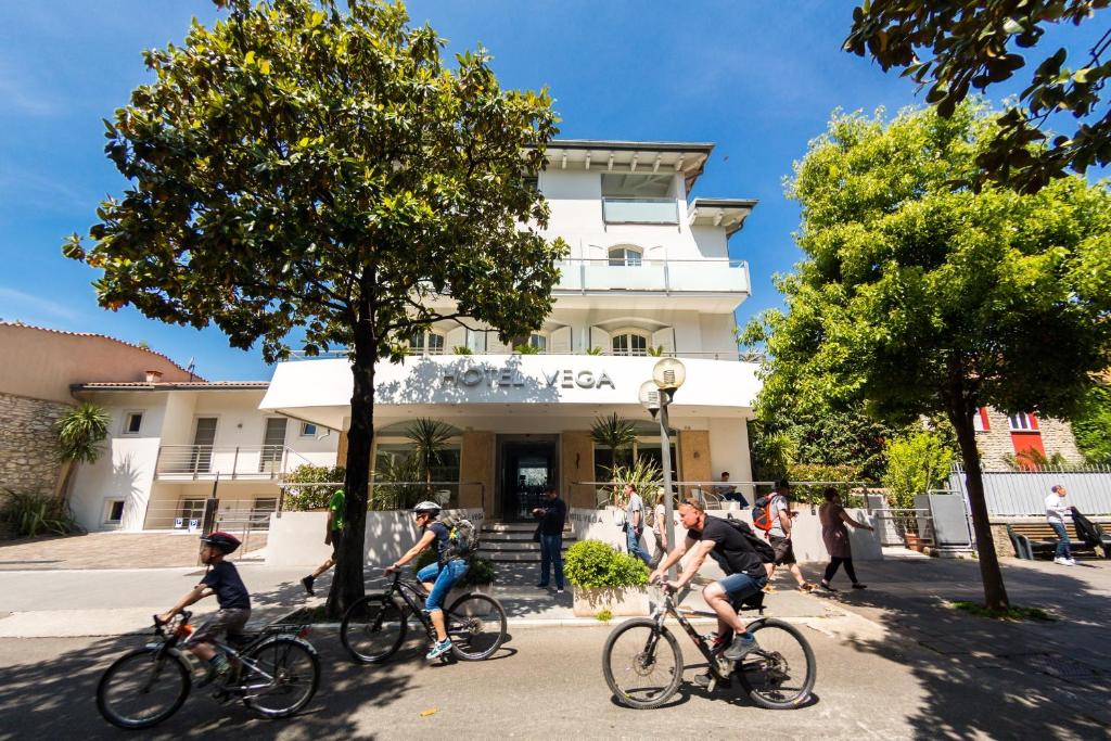 un groupe de personnes à vélo devant un bâtiment dans l'établissement Hotel Vega, à Malcesine
