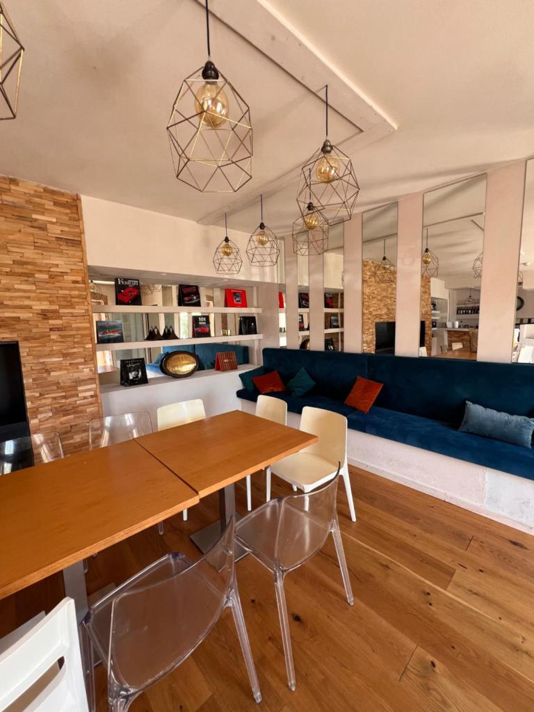 - un salon avec une table en bois et un canapé bleu dans l'établissement Domaine Isaure, à Murisengo