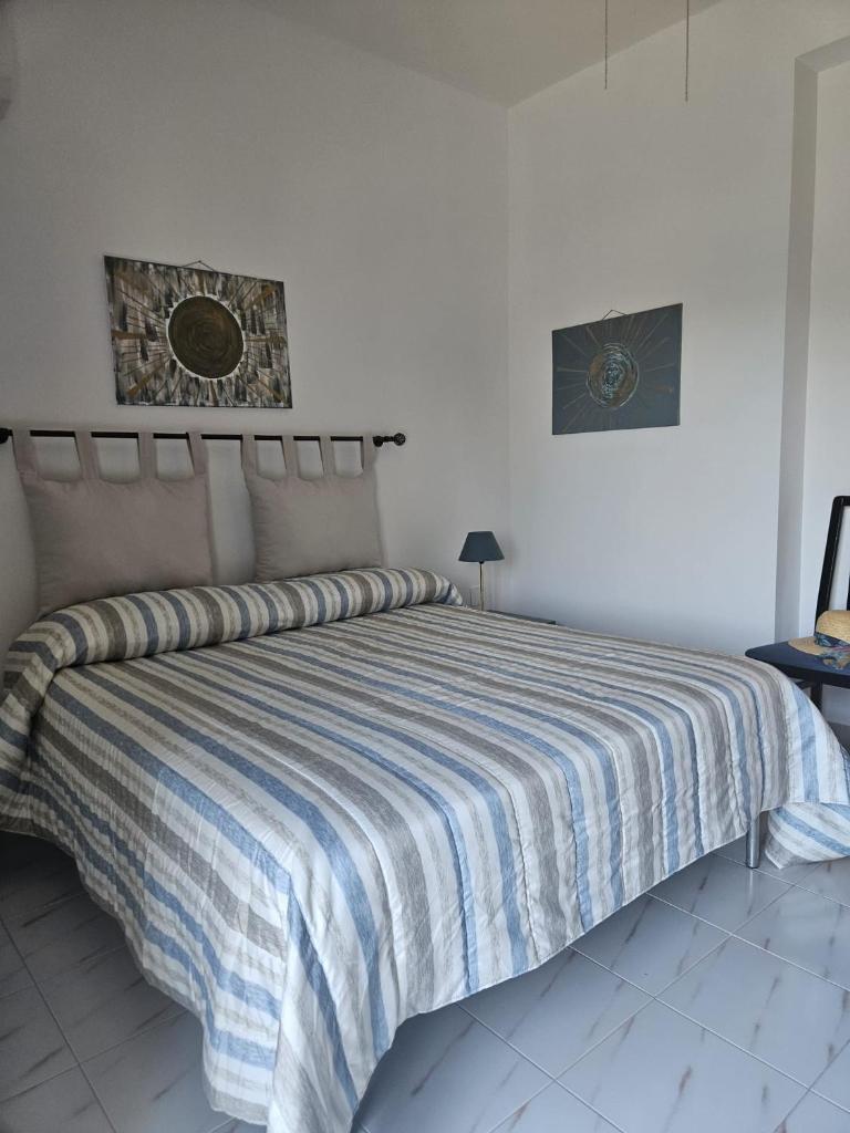 - une chambre avec un grand lit et une couette à rayures dans l'établissement Villa Rosa Holidays, à Altavilla Milicia