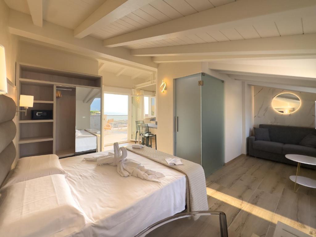 une chambre avec un grand lit blanc et un canapé dans l'établissement Junior Suite Hotel Biagi, à Lido di Camaiore